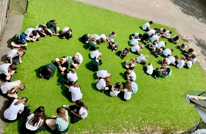 children arranged to spell out the word 'good'